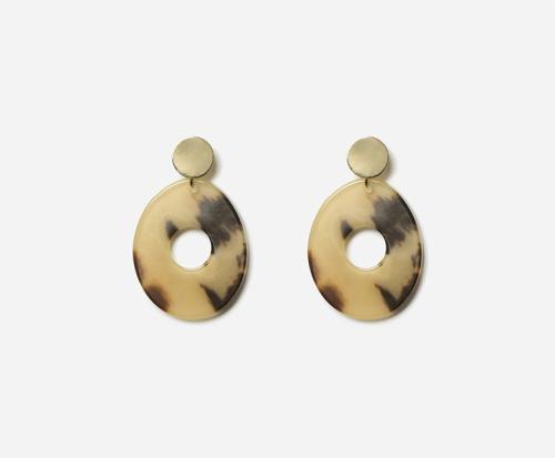 Boucles d'oreilles pendantes composées d'un disque de métal doré et d'un ovale ajouré en résine colorée.